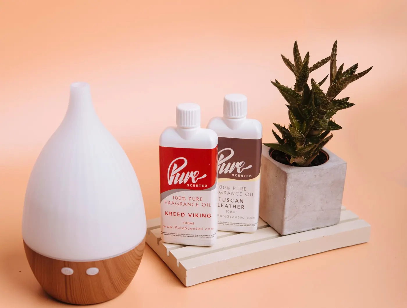 Pure Scented 100ml fragrance oils next to an aroma diffuser